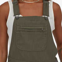 Patagonia Women's Stand Up Overalls in use front view pocket basin gree
